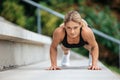 Blonde woman doing push ups outdoor. Royalty Free Stock Photo