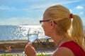 Woman Relaxing with Drink at Seaside