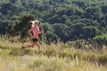 Blonde woman on early morning run with distant tree background. Royalty Free Stock Photo