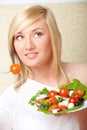 Blonde woman eating healthy food, Greek salad Royalty Free Stock Photo