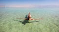 Blonde woman floating in the turquoise waters of the Dead Sea