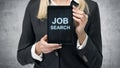 Blonde woman in formal suit presents a tablet with the words 'Job Search' on the screen. A concept of recruitment process. Interns