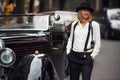 Blonde woman in hat and in black retro clothes near old vintage classic car Royalty Free Stock Photo