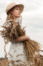 Blonde woman in a hat in a wheat field