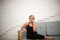 Blonde woman having cellphone conversation while she relaxing on sofa in home interior. Royalty Free Stock Photo