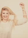 Blonde woman holding hair on clothes hanger