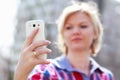 Blonde woman holding smartphone and reading Royalty Free Stock Photo