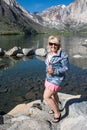 Blonde woman holding a tea poses by Convict Lake in Californias Sierra Nevada Mountains in the spring Royalty Free Stock Photo