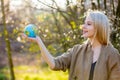 Blonde woman holds Earth globe in blooming cherry garden Royalty Free Stock Photo