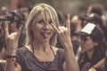 Blonde woman with horns up