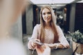 Blonde woman hotel guest checking-in at front desk in hotel