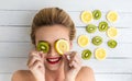 Blonde woman laying next to slices of lemon and kiwi Royalty Free Stock Photo