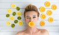 Blonde woman laying next to slices of orange, lemon and kiwi Royalty Free Stock Photo