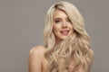 Blonde woman with long curly beautiful hair, studio shot on beige  with free copy space. Royalty Free Stock Photo