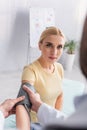 blonde woman looking at blurred doctor