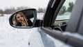 Blonde woman looking in the car rear-view mirror and paint lips. Royalty Free Stock Photo