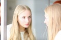 Blonde woman looking at mirror, beauty studio Royalty Free Stock Photo