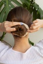 Blonde woman making clean low bun.