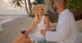 Blonde woman and man in white shirt dating on evening beach having fun and enjoying summer time Royalty Free Stock Photo