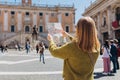 Blonde Woman with paper map is walking on a sunny day. Piazza del Campidoglio on Capitoline Hill, Rome, Italy. Concept Royalty Free Stock Photo