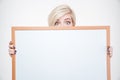 Blonde woman peeking from blank board Royalty Free Stock Photo