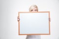 Blonde woman peeking from blank board Royalty Free Stock Photo