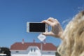 Blonde woman is photographing with smartphone Royalty Free Stock Photo