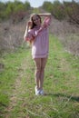 Beautiful blonde woman in pink dress on the road in the garden in the spring Royalty Free Stock Photo