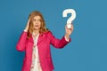 blonde woman in pink jacket holding question mark Royalty Free Stock Photo