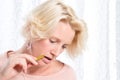 Blonde Woman in Pink Jumper Bites Pencil Whilst Thinking Hard Royalty Free Stock Photo