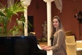 Blonde woman playing the piano. The woman is happy feeling the music