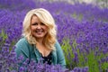 Blonde woman poses in a field of lavender at a farm in Sequim Washington during the lavender festival summer season, looking Royalty Free Stock Photo