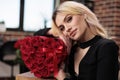 Blonde woman with roses looking at camera close up Royalty Free Stock Photo