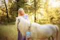 Woman in purple dress hugging white unicorn horse. Dreams come true. Fairy tale Royalty Free Stock Photo