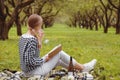 Blonde Woman Relaxing with the Book alone on a Picnic Drinking Wine Royalty Free Stock Photo