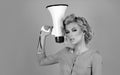 Blonde woman in retro style shouting through a megaphone. Idea for marketing or sales banner. Royalty Free Stock Photo