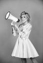 Blonde woman in retro style shouting through a megaphone. Shout girl speaks in a loudspeaker megaphone. Royalty Free Stock Photo