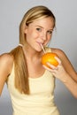 Blonde Woman Sipping Juice from Orange Royalty Free Stock Photo