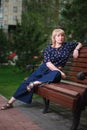 Blonde woman sitting on a bench Royalty Free Stock Photo