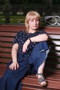 Blonde woman sitting on a bench Royalty Free Stock Photo