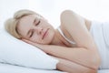 Woman peacefully sleeping on a soft white bed. Royalty Free Stock Photo