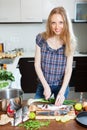 Blonde woman slicing raw fish Royalty Free Stock Photo