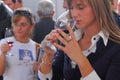 Blonde woman smell wine from her glass at food fair Turin Italy