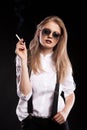 Blonde woman smoking on black background Royalty Free Stock Photo