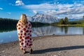 Blonde woman snuggled in a pumpkin blanket enjoys the morning view at Two Jack Lake in Banff National Park Canada Royalty Free Stock Photo