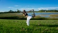 blonde woman spiritual doing yoga king dance standing pulling bow Natarajasana / Dandayamana Dhanurasana pose in nature Royalty Free Stock Photo