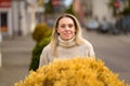 Blonde woman standing behind yellow flowers Royalty Free Stock Photo