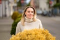 Blonde woman standing behind yellow flowers Royalty Free Stock Photo