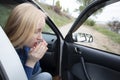 Nausea during a car trip. A blonde woman suffers from kinetosis. The concept of motion sickness in diseases of the transport and Royalty Free Stock Photo