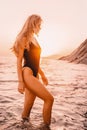 Blonde woman in swimwear bikini on quiet sea with sunset colors. Girl on vacation Royalty Free Stock Photo